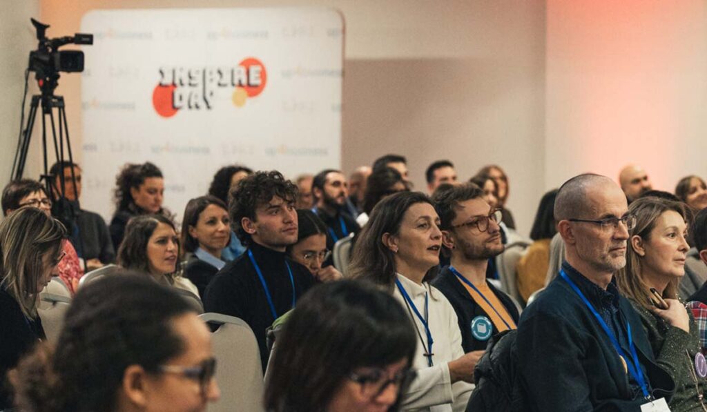 Una vista della sala di formazione con persone sedute che ascoltano gli speech.