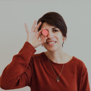 Foto in posa di Sarah saccullo, donna con capelli corti, sorridente e maglione ocra.
