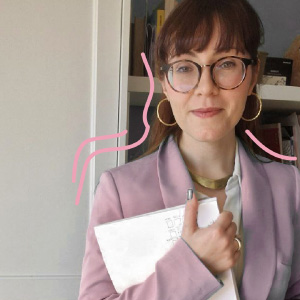 Foto in primo piano di sthefanie valeriano, donna con frangia e occhiali, con giacca rosa